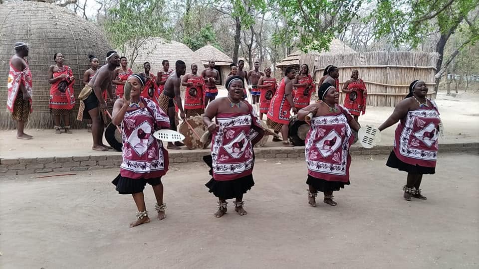 Traditional dancers performing in a village setting