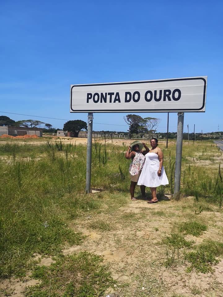 Travellers at the Ponta do Ouro destination sign in Mozambique